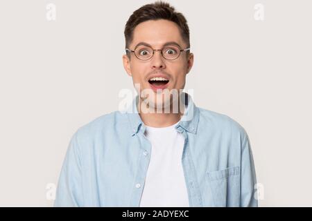 Surprised millennial man with eyes wide open looking at camera Stock Photo