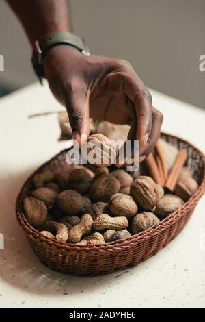 Peanuts and walnuts in wicker basket on the table Stock Photo