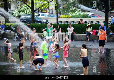 Chicago, Illinois, USA. Children play and cool off at Crown Fountain in Chicago's Millennium Park on a hot summer day. Stock Photo