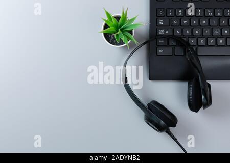 Keyboard a plants and earphones on a gray background with microphone with copy space Stock Photo