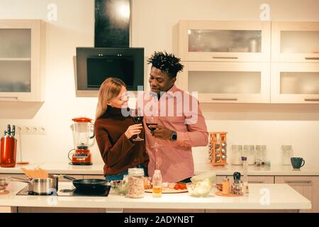 Long haired lady smiling wheil drinking wine with boyfriend Stock Photo
