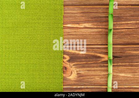 Bamboo branch with green towel on wooden background. Top view with copy space for your text. Plastic free, Eco friendly, Zero waste mock up Stock Photo