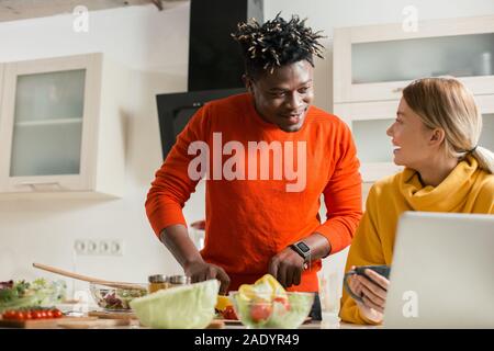 Man cooking and his smiling girlfriend looking at him Stock Photo