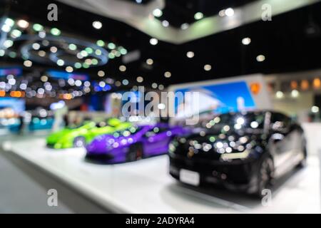 Blurred background of new cars displayed in luxury showroom with light bokeh, motor show event. Stock Photo