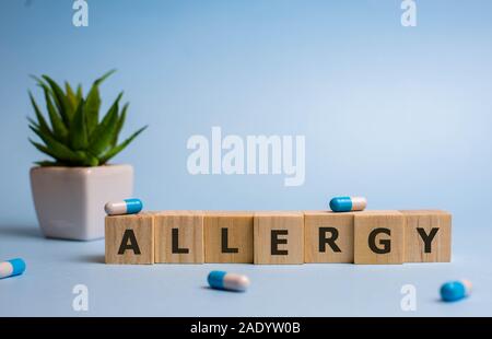 wooden cubes with word Allergy on blue backgound Stock Photo