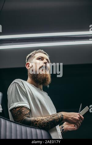 Waist up of calm bearded man looking into the distance Stock Photo