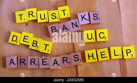 Scrabble letters,- word, words, Trust,Banks, Debt, Arrears, Help, UC, Universal Credit - issues encountered by poor residents Stock Photo