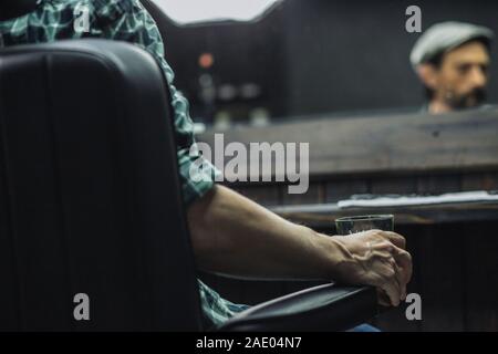 Close up of glass of alcohol in the hand of man Stock Photo