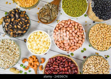 Different whole grains beans on bowl and legumes seeds lentils and nuts colorful snack background top view / Collage various beans mix peas agricultur Stock Photo