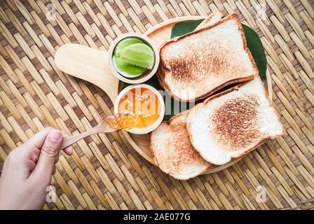 toast bread served on wooden tray with sweet jam and lime homemade breakfast Stock Photo