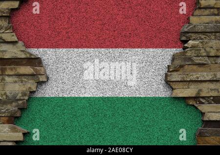 Hungary flag depicted in paint colors on old stone wall close up. Textured banner on rock wall background Stock Photo