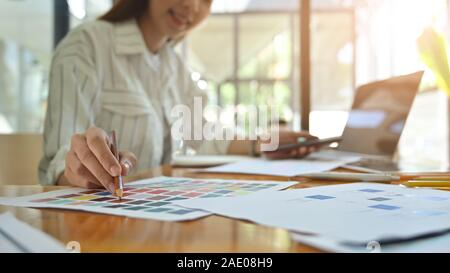 Close-up creative graphic designer with her working on colour selection on paper colour. Stock Photo