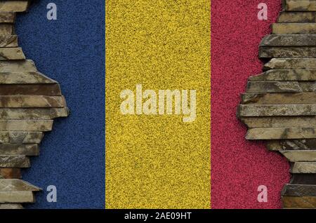 Chad flag depicted in paint colors on old stone wall close up. Textured banner on rock wall background Stock Photo