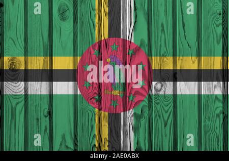 Dominica flag depicted in bright paint colors on old wooden wall close up. Textured banner on rough background Stock Photo