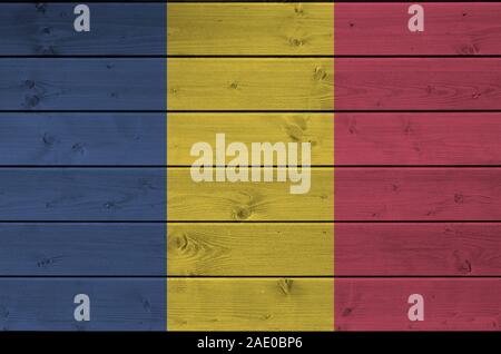 Chad flag depicted in bright paint colors on old wooden wall close up. Textured banner on rough background Stock Photo