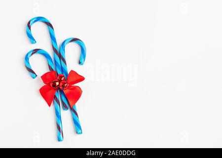 Group of blue candy canes tied with a red ribbon and bells. Stock Photo