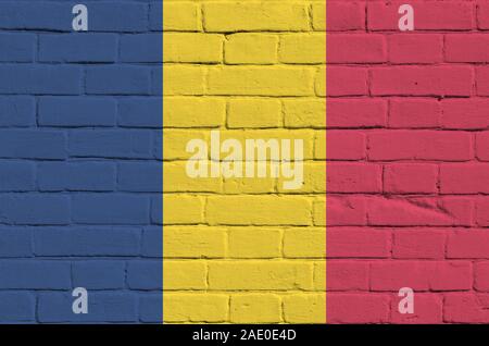 Chad flag depicted in paint colors on old brick wall close up. Textured banner on big brick wall masonry background Stock Photo