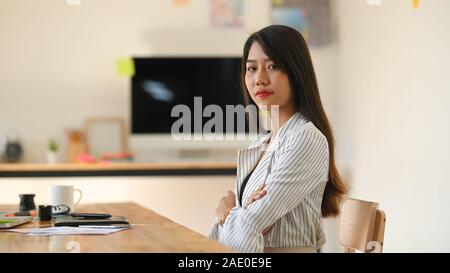Confidently attractive young woman sitting on creative studio.