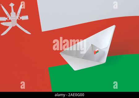 Oman flag depicted on paper origami ship closeup. Oriental handmade arts concept Stock Photo