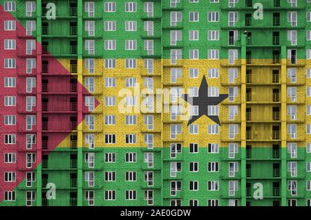 Sao Tome and Principe flag depicted in paint colors on multi-storey residental building under construction. Textured banner on big brick wall backgrou Stock Photo