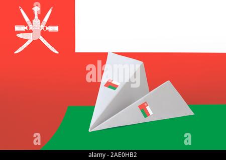 Oman flag depicted on paper origami airplane. Oriental handmade arts concept Stock Photo