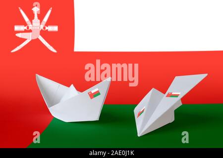 Oman flag depicted on paper origami airplane and boat. Oriental handmade arts concept Stock Photo
