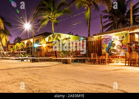 San Pedro, Ambergris Caye, Belize - November, 17, 2019. A street view of bright restaurants on Ambergris Caye island beach at night. Stock Photo