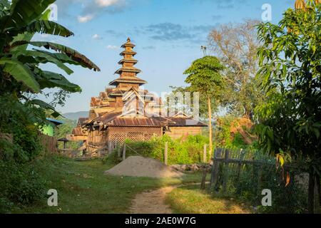 A beautiful architectural temple made of wood at the base of a footpath in a remote village in northwestern Myanmar (Burma) Stock Photo