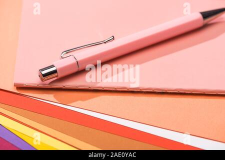 selective focus of pen and notebook on bright and colorful papers Stock Photo