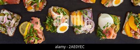 panoramic shot of rye bread with tasty smorrebrod sandwiches on grey surface Stock Photo