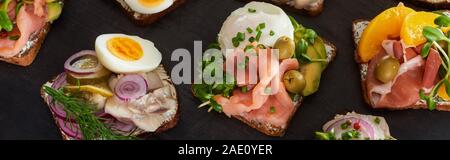 panoramic shot of rye bread with prepared danish smorrebrod sandwiches on grey surface Stock Photo