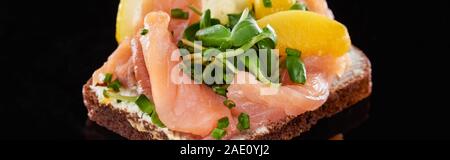 panoramic shot of salmon on tasty smorrebrod sandwich on black Stock Photo