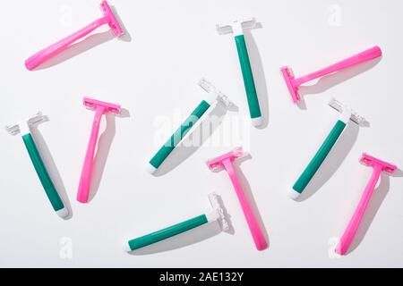 top view of female pink and green disposable razors on white background Stock Photo