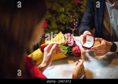 partial view of man presenting wedding ring to girlfriend while making marriage proposal Stock Photo
