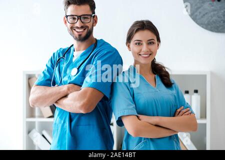 two young, confident veterinarians standing with crossed arms and smiling at camera Stock Photo