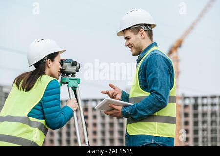 Surveyors using tablet and digital level on construction site Stock Photo