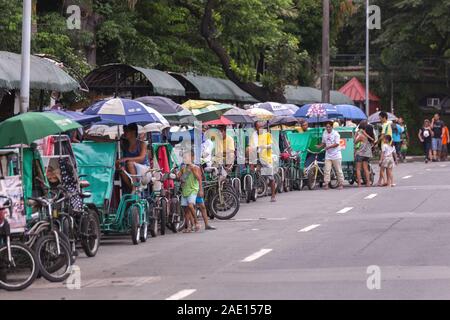 Manila, Philippines - August 23, 2017: Many philippine tricycles with drivers in road street Stock Photo