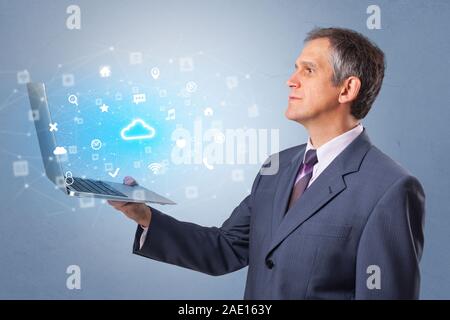 Man holding laptop projecting notifications, symbols and information based on cloud technology system Stock Photo
