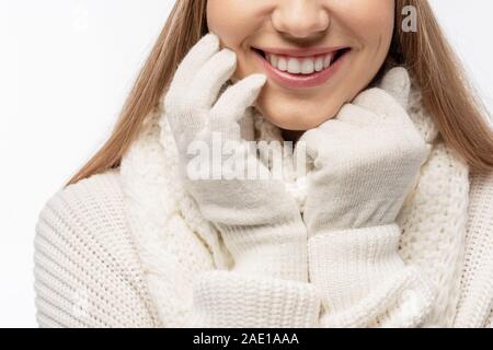 cropped view of smiling woman warming up in white knitted gloves, isolated on white Stock Photo