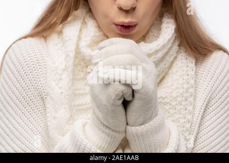cropped view of girl warming up in white knitted clothes and gloves, isolated on white Stock Photo