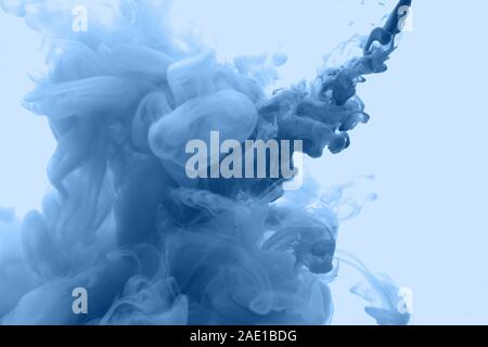 Ink in water in a classic blue color. Look like a cloud or smoke or without gravity. Stock Photo