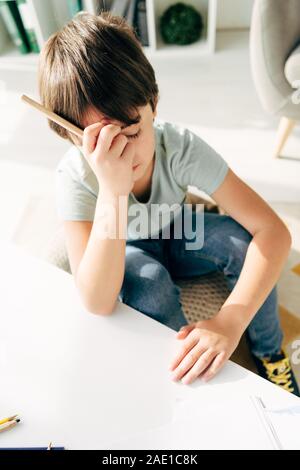 high angle view of kid with dyslexia sitting on floor with teddy bear ...