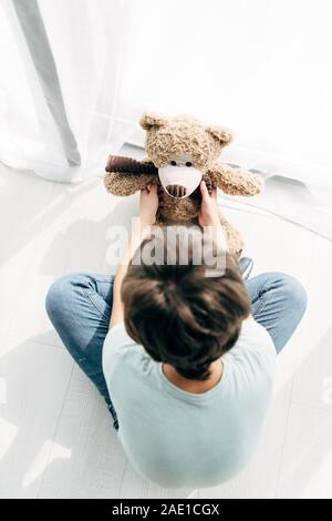 kid with dyslexia sitting on floor with building blocks on white ...