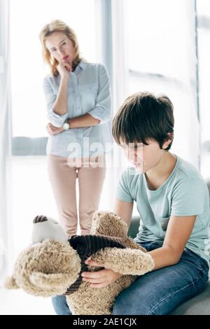 kid with dyslexia holding teddy bear and child psychologist hugging him ...