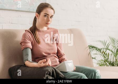 young girl looking at tonometer while measuring blood pressure Stock Photo