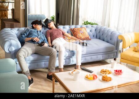 Young couple wearing VR glasses at home Stock Photo
