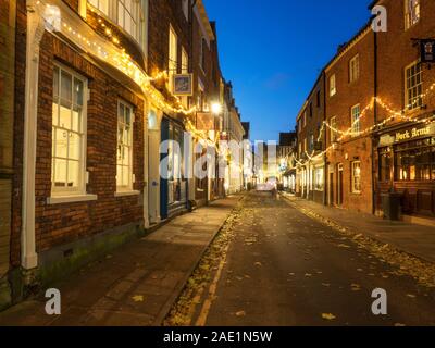 Christmas lights along High Petergate towards Bootham Bar at dusk City of York Yorkshire England Stock Photo