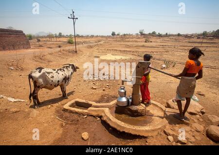 Tribal woman pumping water from hand pump, Nandgaon, Atgaon, Maharashtra, India, Asia Stock Photo