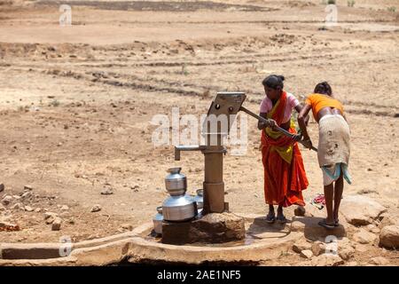Tribal woman pumping water from hand pump, Nandgaon, Atgaon, Maharashtra, India, Asia Stock Photo