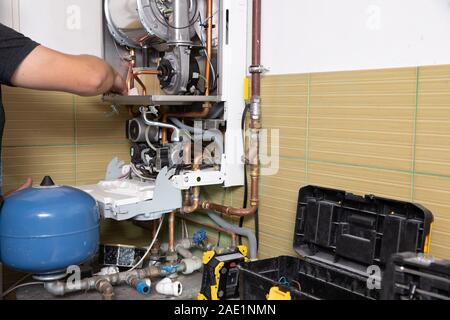 Master of gas service, adjusts the combustion gas on the gas boiler Stock Photo